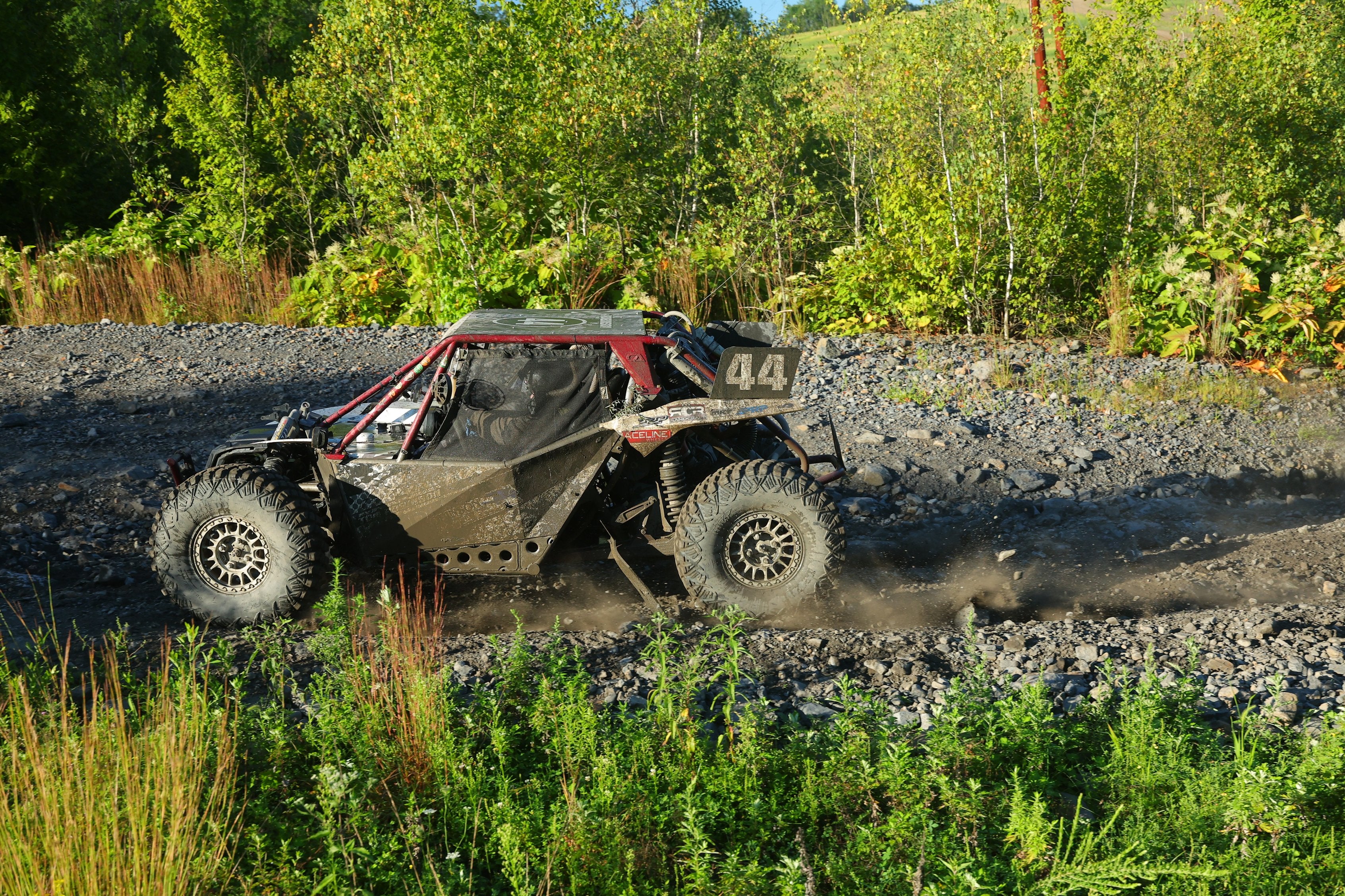 Number 44 side-by-side racing through a rocky course